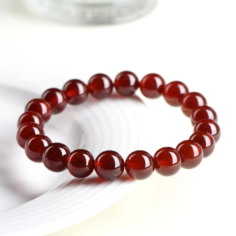Close-up of a natural orange red garnet crystal bracelet in a unisex retro style with Ruyi design elements.