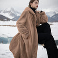 Long brown leopard print faux fur coat on a hanger, showing its loose fit and regular sleeves.