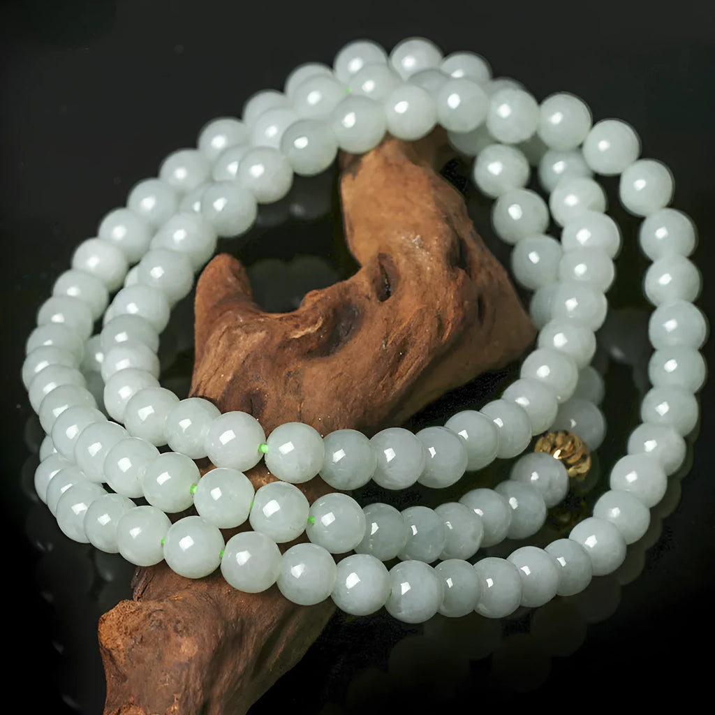 Adjustable necklace with a round white and green jade bead on a silver chain.