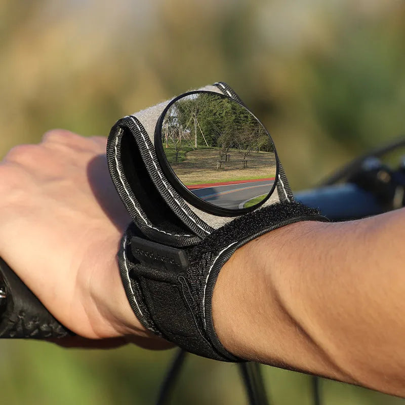 Black nylon bicycle wrist rear-view mirror with adjustable arm extended for cycling visibility