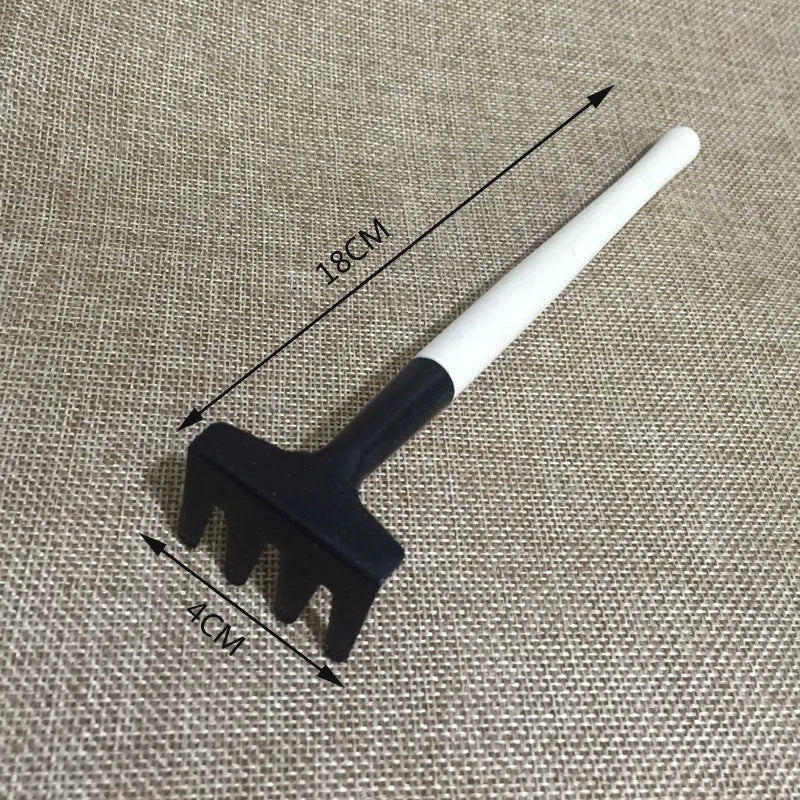 A succulent gardening tool set showing a mini watering can, bucket, tweezers, drip kettle, shovel, rake, and brush on a table.