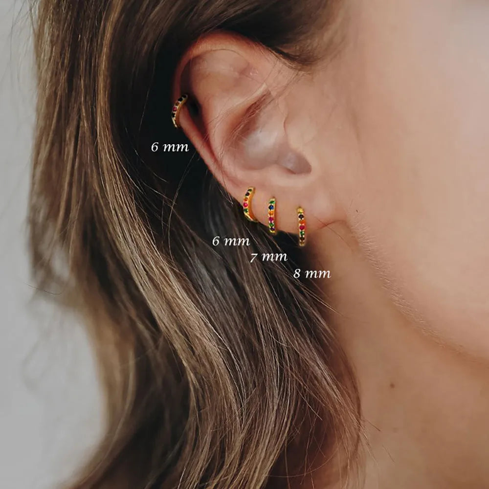 A pair of perforated circular stud earrings with zircon detailing in gold, rose gold, or silver colour.