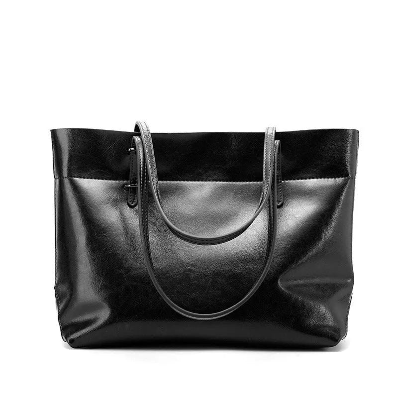 Brown leather cross-body handbag with a horizontal design showing two main compartments and a long strap.