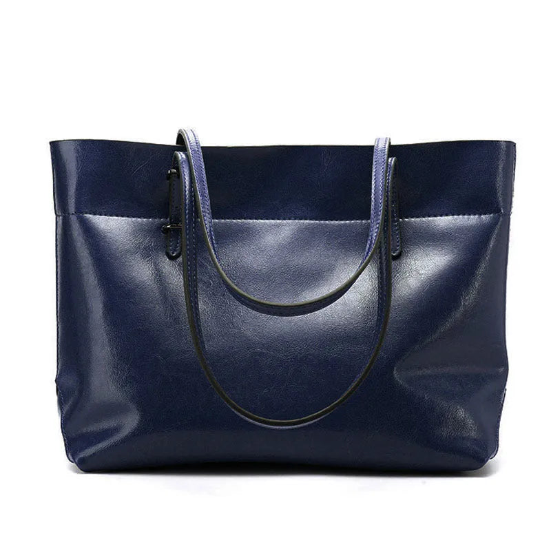 Brown leather cross-body handbag with a horizontal design showing two main compartments and a long strap.