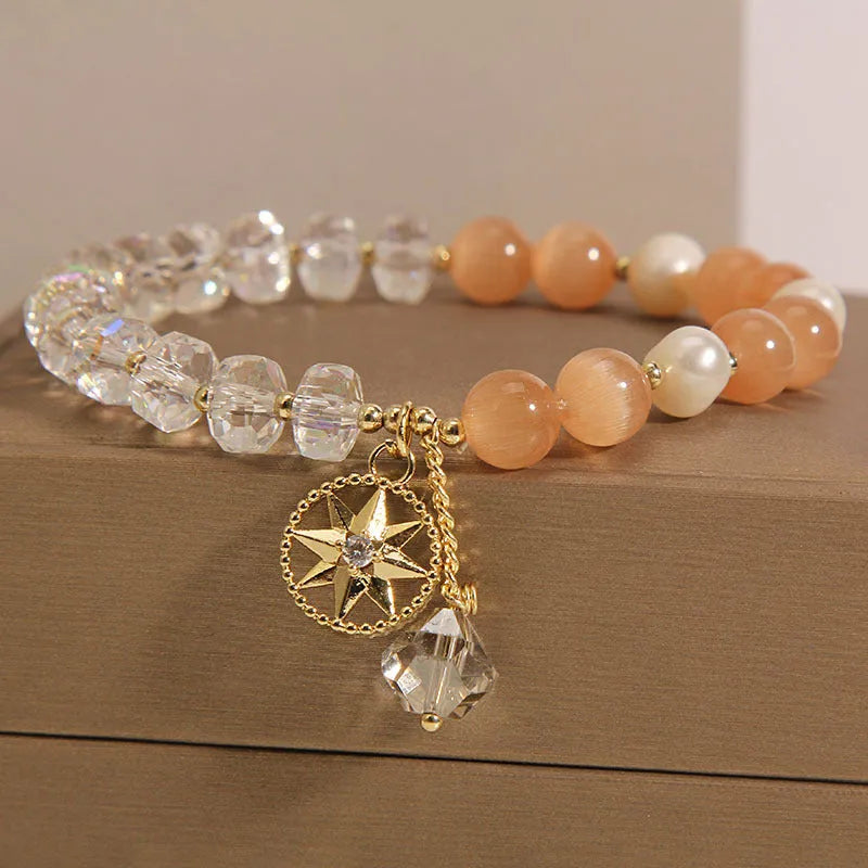 Gold-plated women's bracelet with an eight Awn star design and an orange crystal inlay.