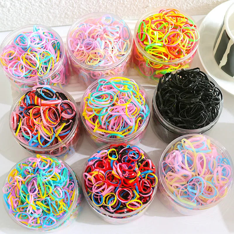 Assorted colourful TPU baby hair ties in a reusable plastic container.