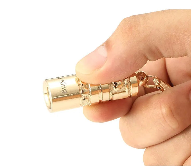Gold-coloured zinc alloy die-cast LED keychain flashlight with attached key ring.