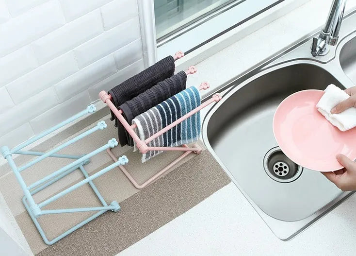 Light grey foldable plastic dishcloth shelf on a kitchen countertop
