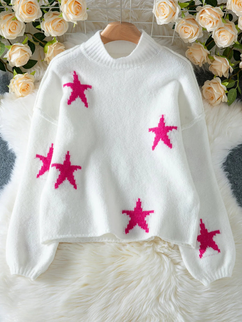 White women's loose turtleneck pullover with a black five-pointed star pattern on the front.