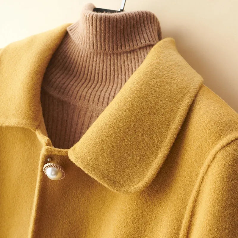 Women's mid-length wool coat with pearl buckle fastening and doll collar in solid colour