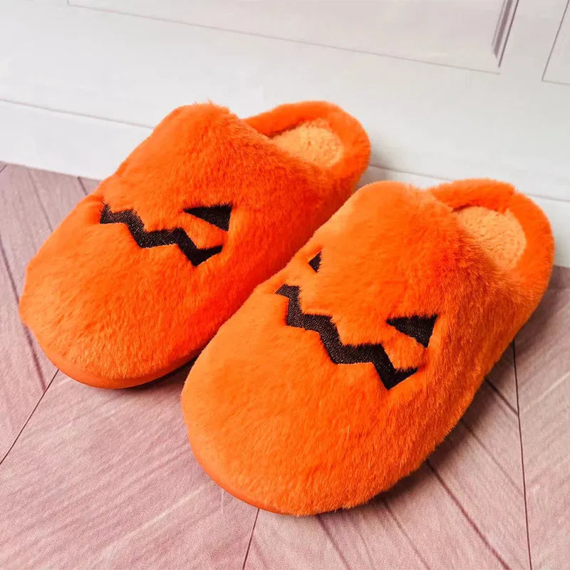 Orange Halloween pumpkin-themed plush slippers with a coral velvet upper and flat heel.
