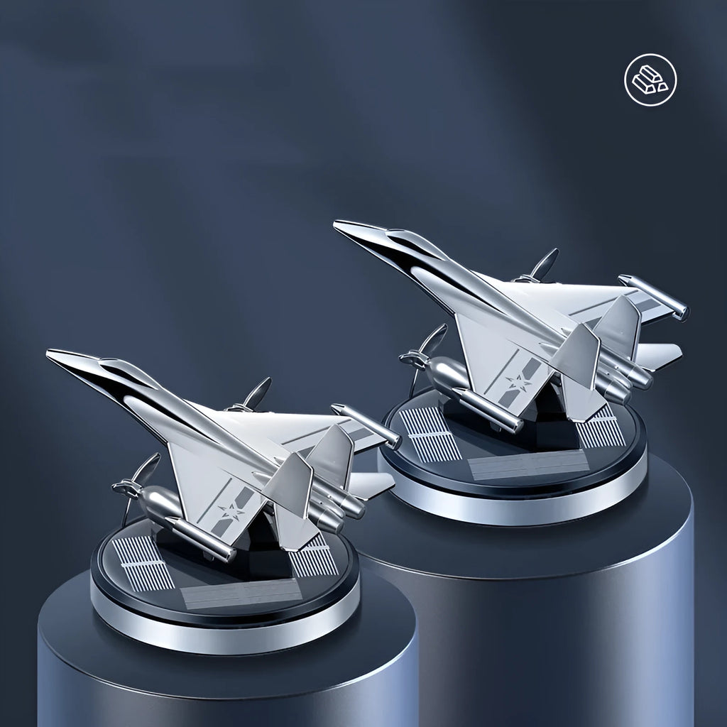 Silver solar powered rotating fighter jet perfume ornament on a wooden surface.