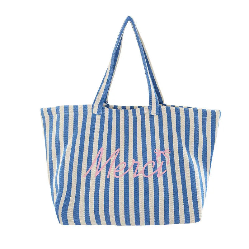 Pink cotton canvas bag with a printed design of blue and white striped letters.