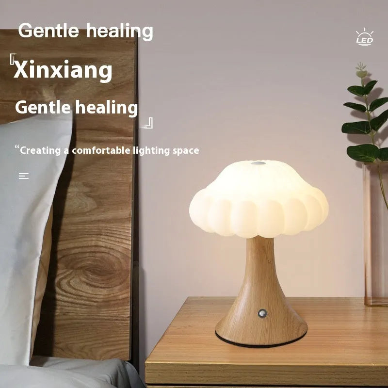 Small mushroom-shaped night lamp on a charging base in wood grain colour finish.