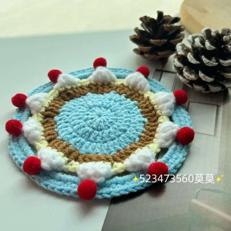A single 9cm round wool coaster and its decorative cake-themed storage bag.