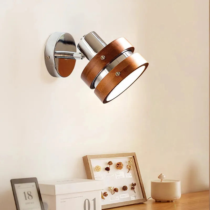 Small Scandinavian-style wall lamp with walnut wood finish, mounted on a wall.