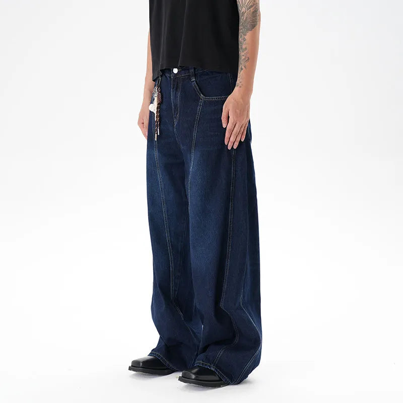 Dark blue wide-leg jeans with a distressed wash on a denim fabric, showing a relaxed fit.