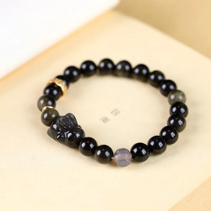 Handmade obsidian bracelet with lying rabbit charm, grey agate accents, and Yaoshi metallic elements in traditional national style