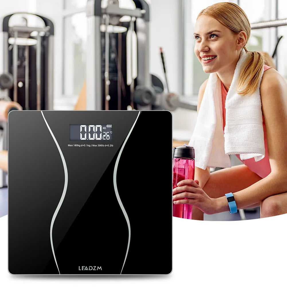 Black electronic household bathroom scale on a floor.