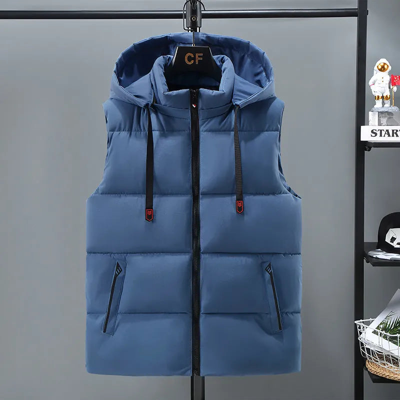 Man wearing a solid blue thickened vest with a removable hood and slant pockets.
