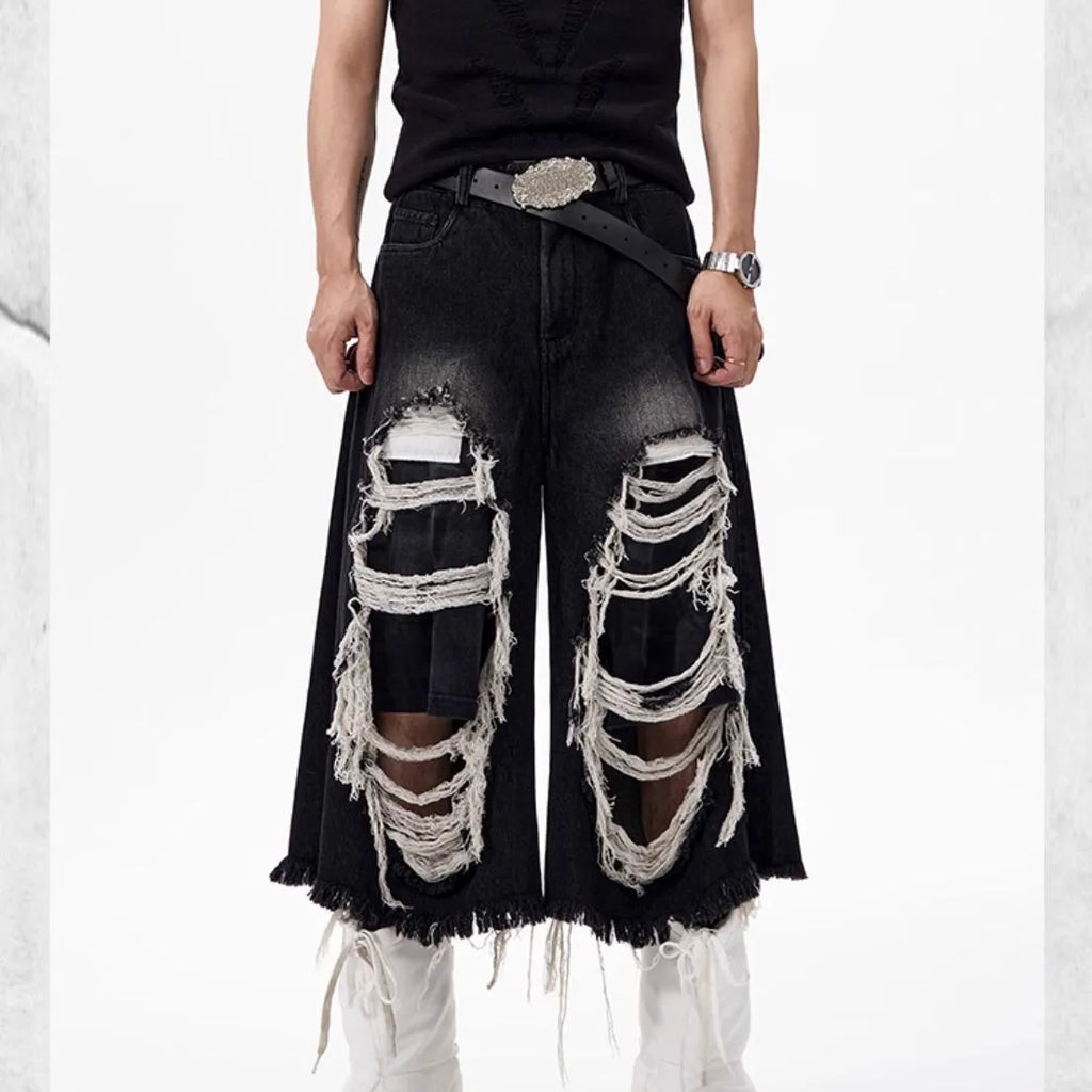 Model wearing black cropped wide-leg jeans with a distressed patch detail on the leg.