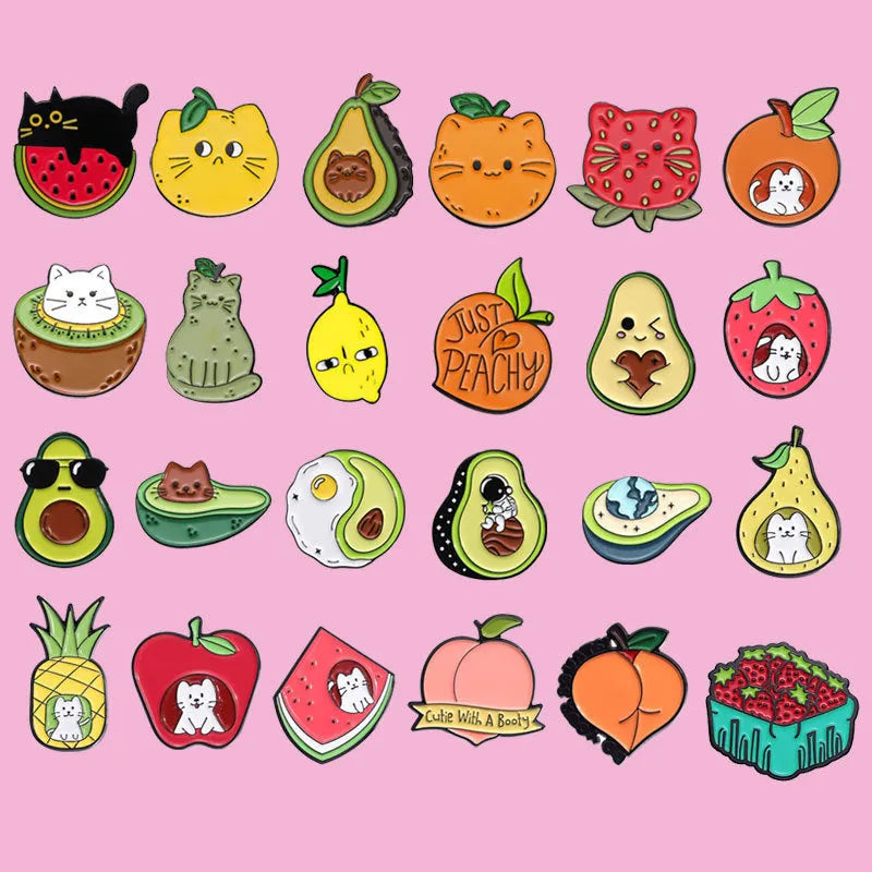 Colourful cartoon fruit and letter design on a metal brooch pin with a secure clasp.