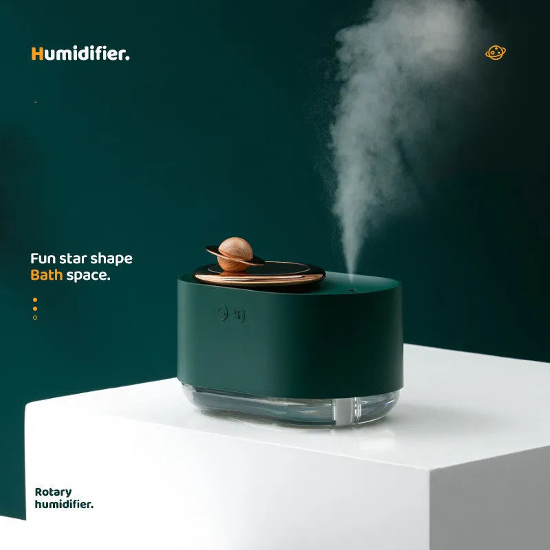 Green rotating planet-shaped USB humidifier with night light on a wooden desk.
