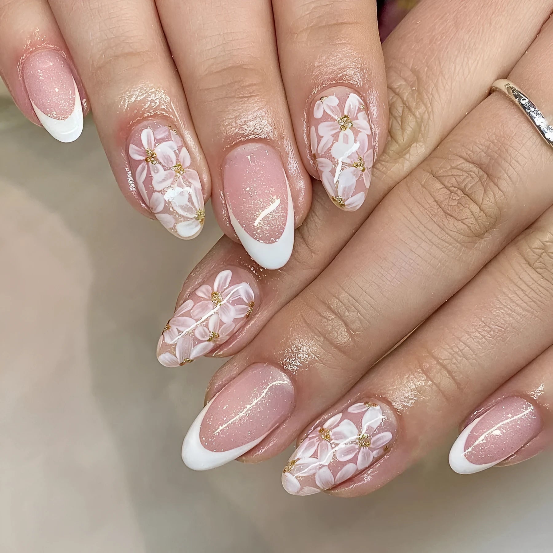 Short glossy almond French style press-on nails with glittering powder flowers in colour C625