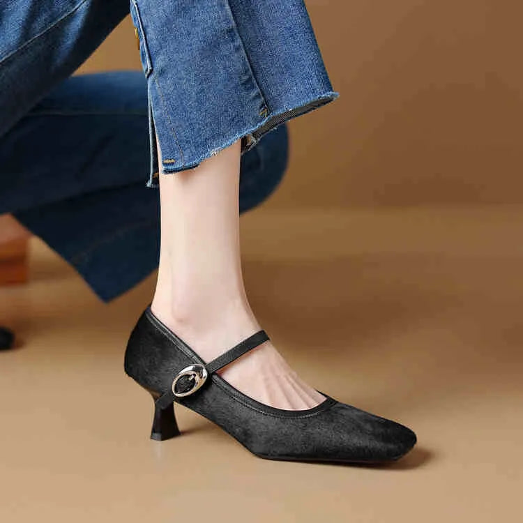 Women's black square toe stiletto heel ankle-strap shoes with horse hair upper on a model.