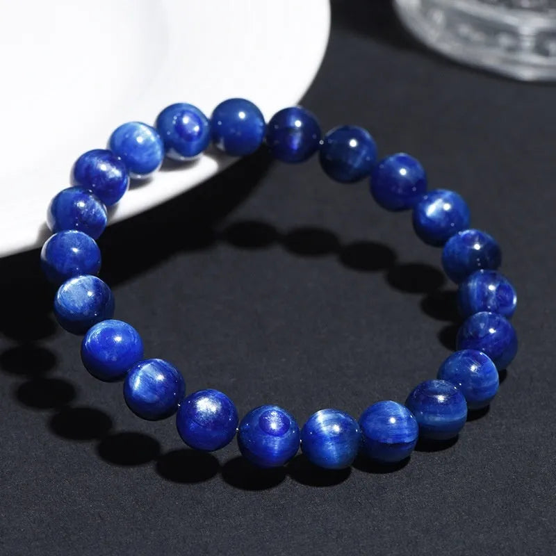 Blue crystal ball bracelet with geometric design and Ruyi motif on a white background.