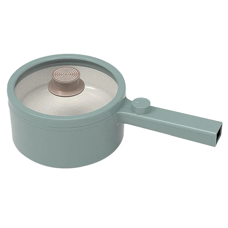 White and green multi-function electric cooking pot with temperature control dial, shown with a UK plug converter.