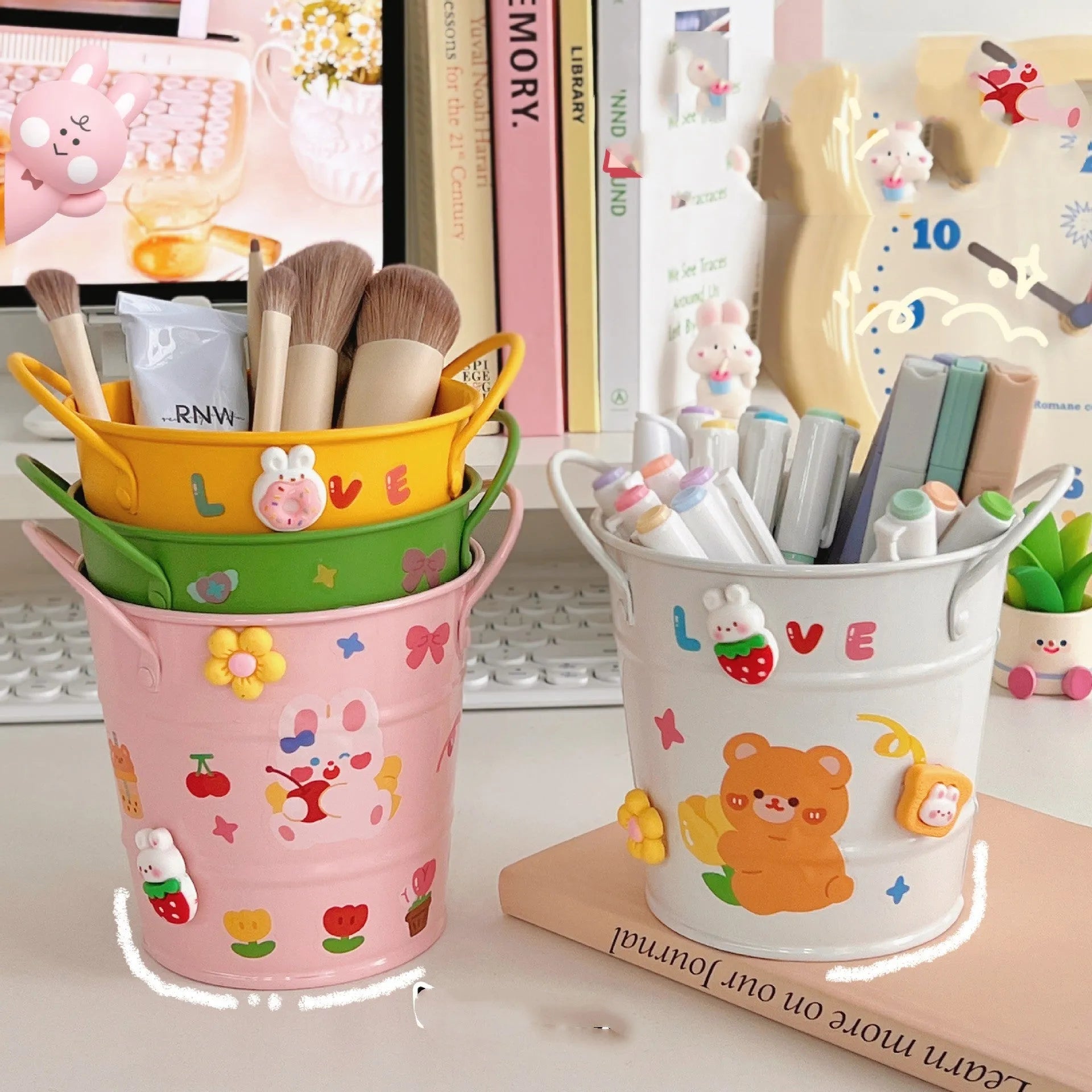 Round metal pen holder in a choice of colours including green, pink, and red on a wooden desk