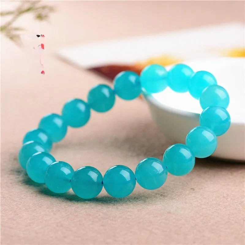 Selection of polished blue-green Amazonite scattered beads in different sizes for making a crystal bracelet.