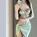 Green women's bikini three-piece set with triangle top, briefs, and matching skirt