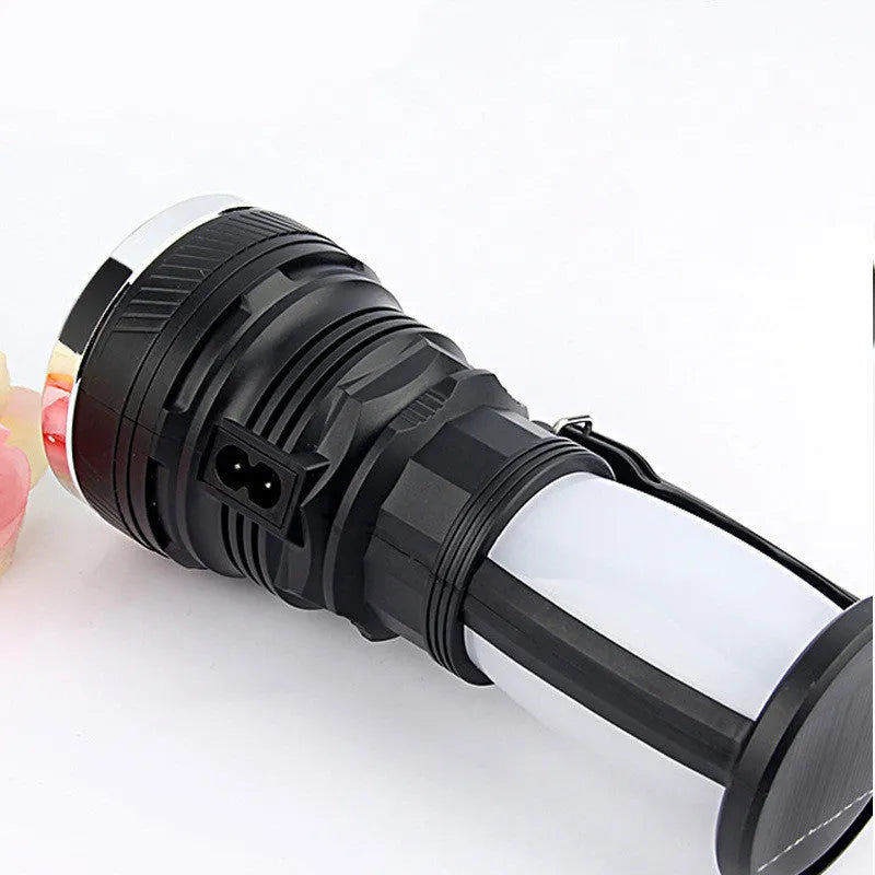 Black solar charging LED emergency flashlight with USB port on a textured surface.