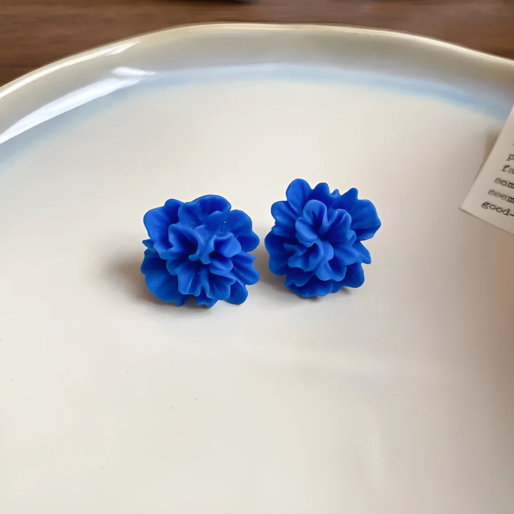Geometric-shaped cloth earrings in silver needle and blue resin flower colours.