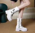 Women's black mid-calf knight boots with a large metal buckle and side zip.