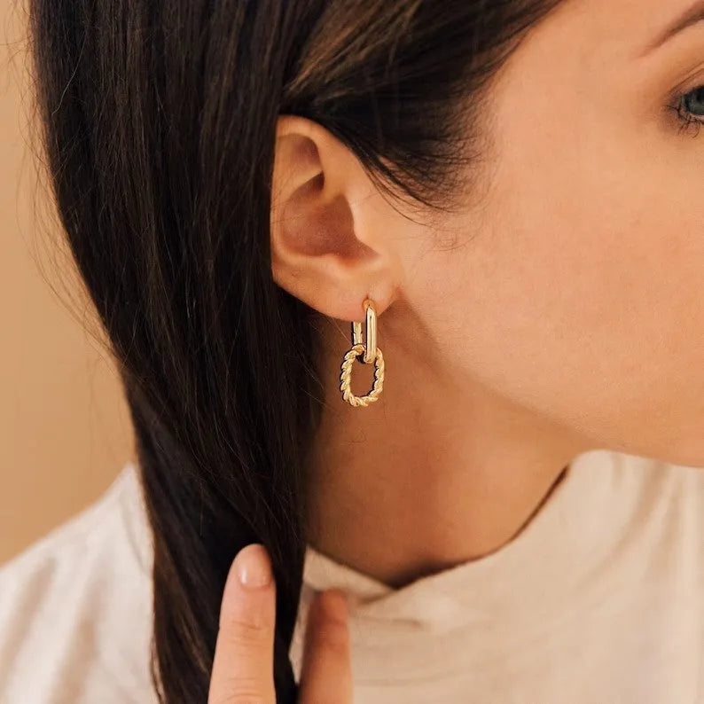 Double ring twist geometric square ear clip simple copper earrings on a neutral background