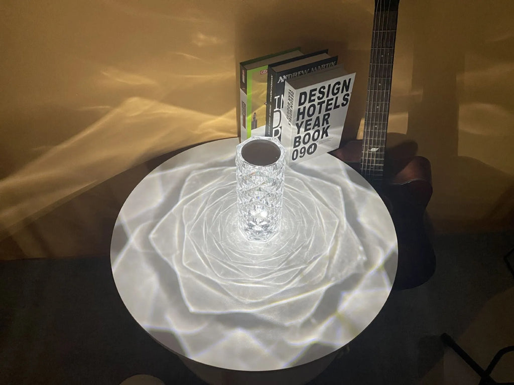 Creative acrylic crystal rose LED table lamp with adjustable three-colour lighting on a wooden surface.