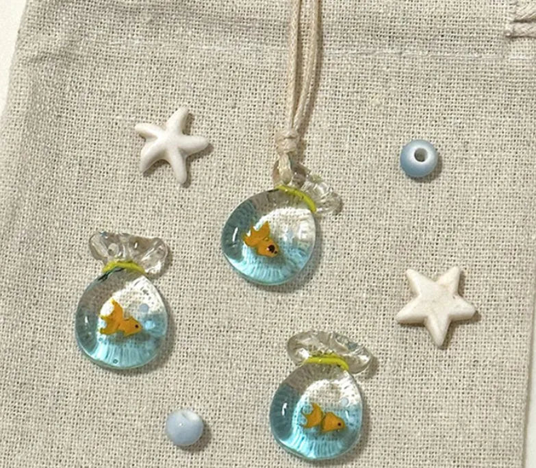 Women's necklace with coloured glaze joker pendant on a beige cotton linen clavicle chain.