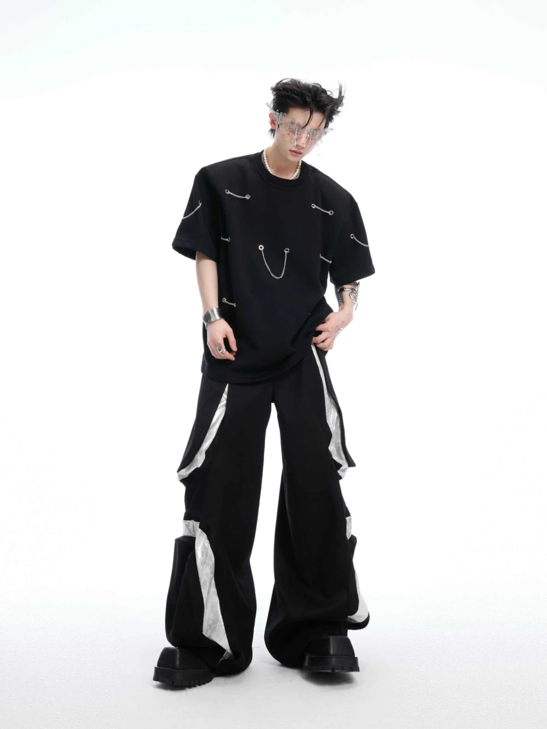 Black T-shirt with padded shoulders and metal chain detail on short sleeves