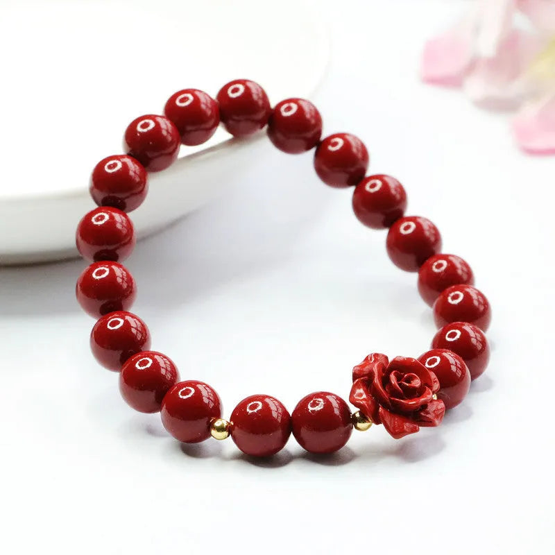 Close-up of a women's natural cinnabar bracelet with a detailed 8mm purple gold sand rose centrepiece.