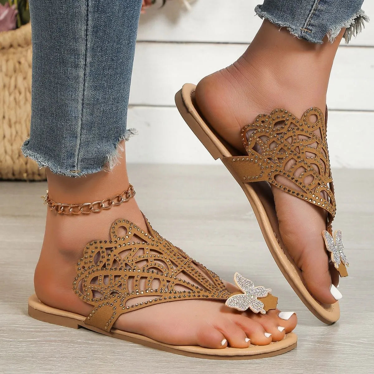 Women's black slip-on sandals with rhinestone detail, flip-toe design, and flat rubber sole.