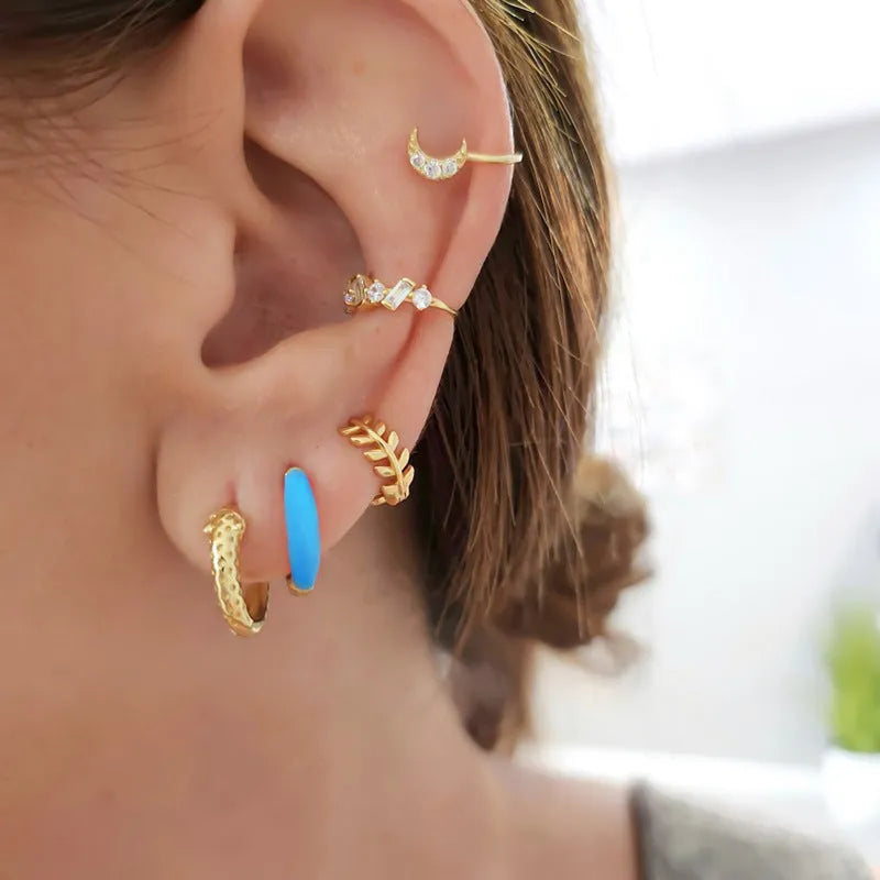 Geometric oval curved earrings for women in silver copper with a blue epoxy drip finish on a U-shaped wire.