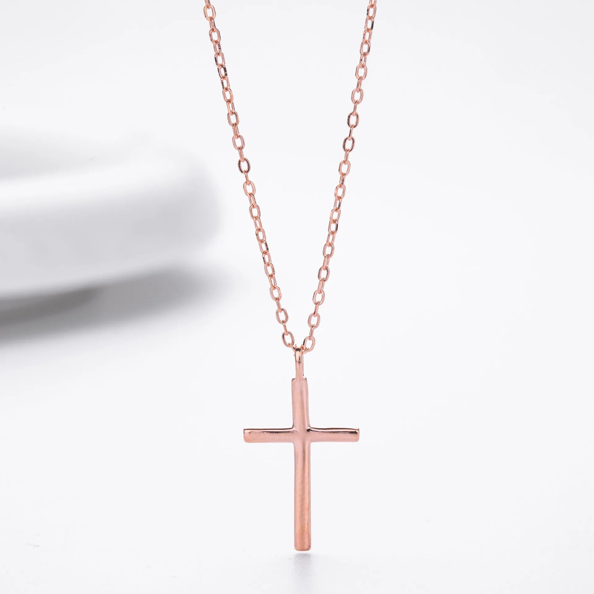 Simple glossy cross pendant on an adjustable O-shaped sterling silver chain.