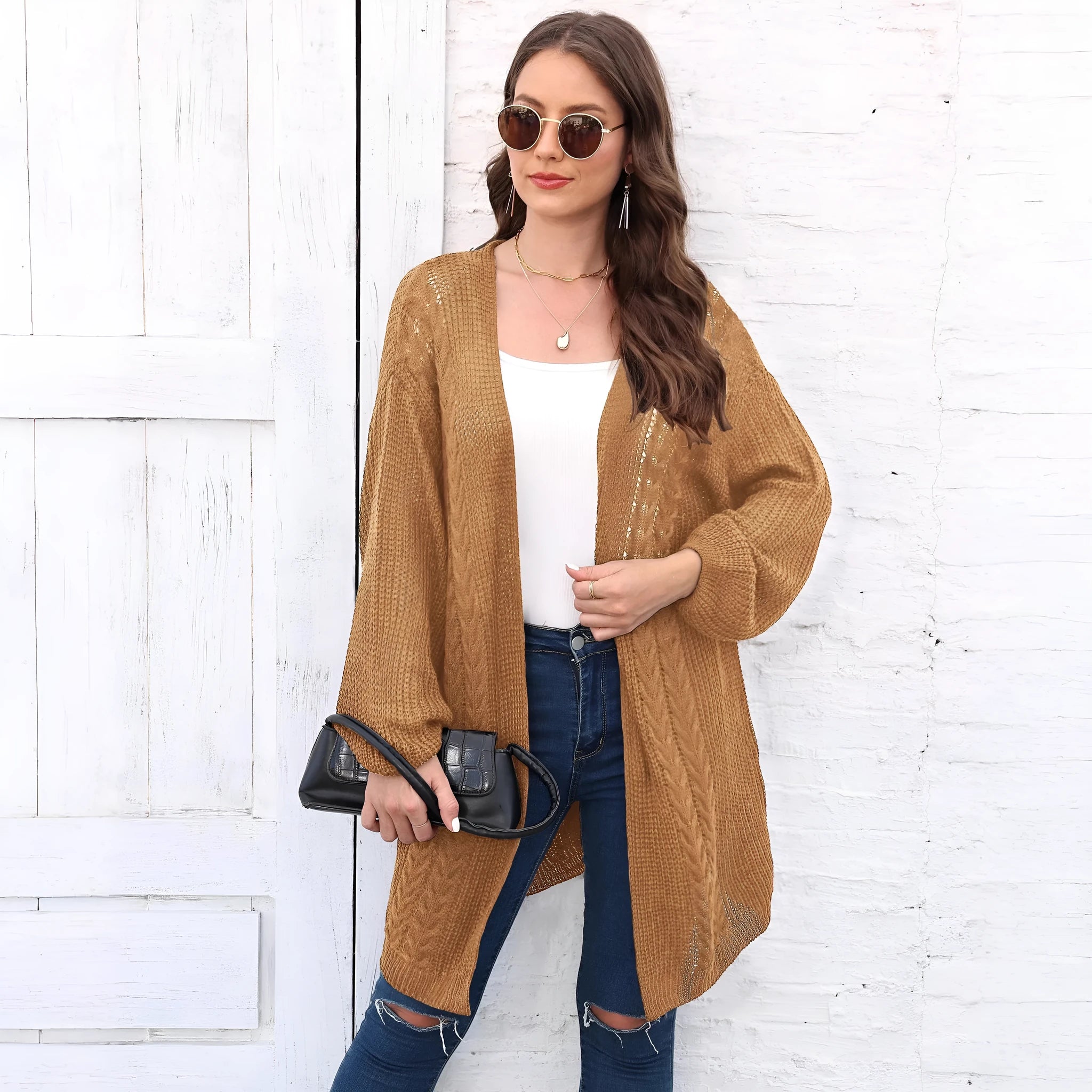 Women's loose-fitting solid colour acrylic sweater coat on a hanger