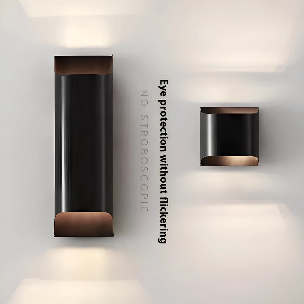 Minimalist copper wall lamp in black gold finish mounted beside a bed