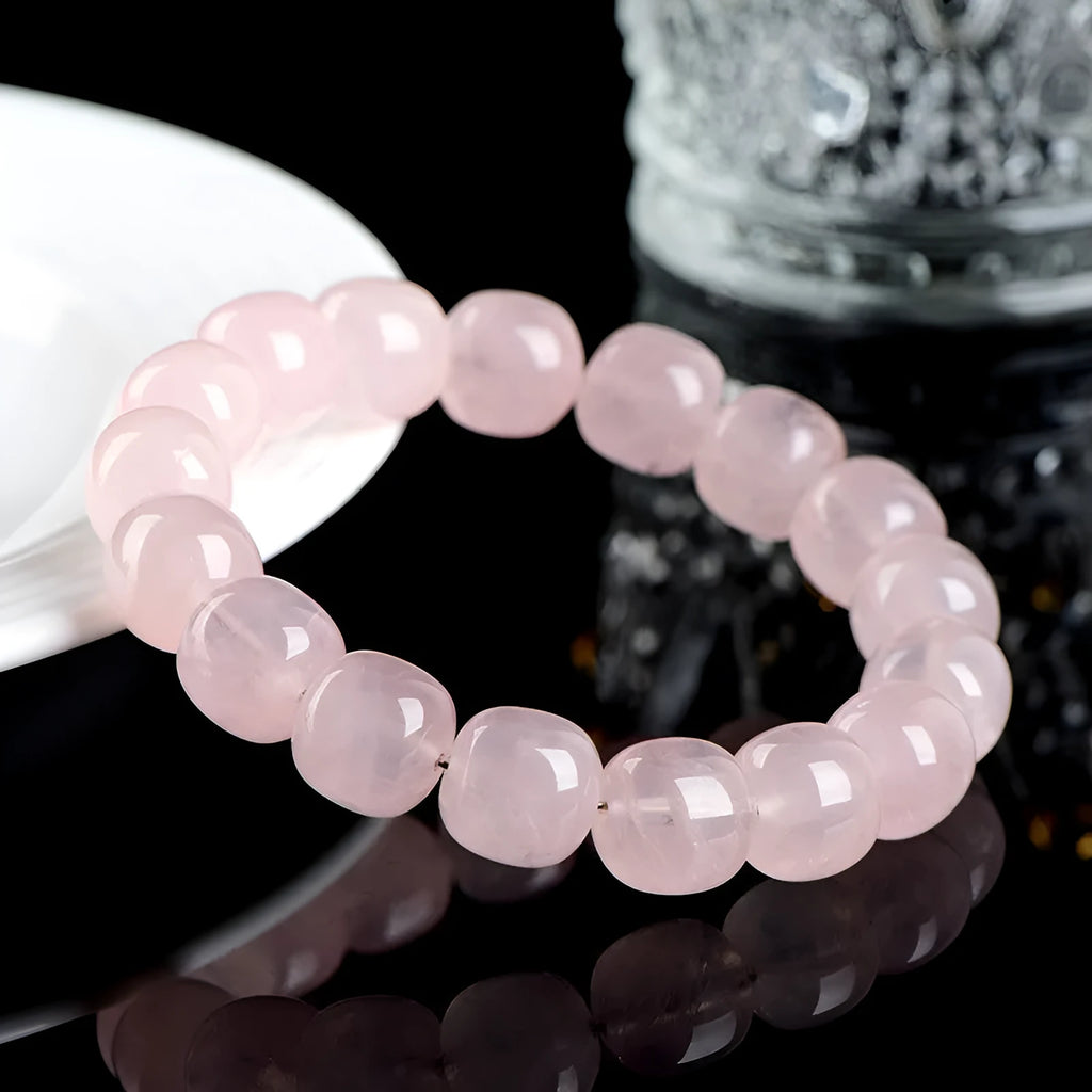 Close-up of a pink crystal bracelet with barrel-shaped beads on a wrist.