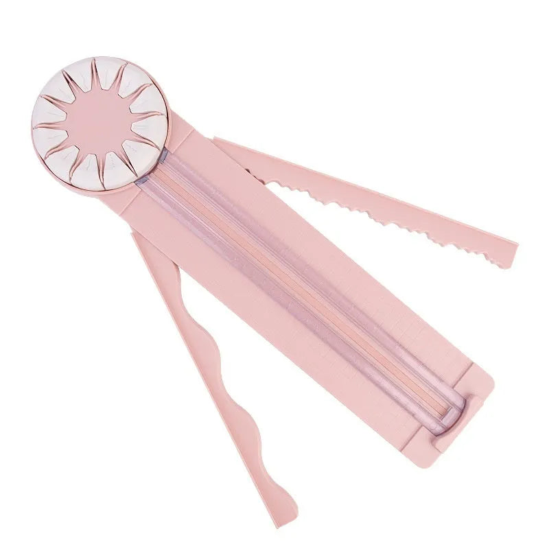 Pink plastic 12-in-1 multifunctional paper cutting machine for crafts on a white background.