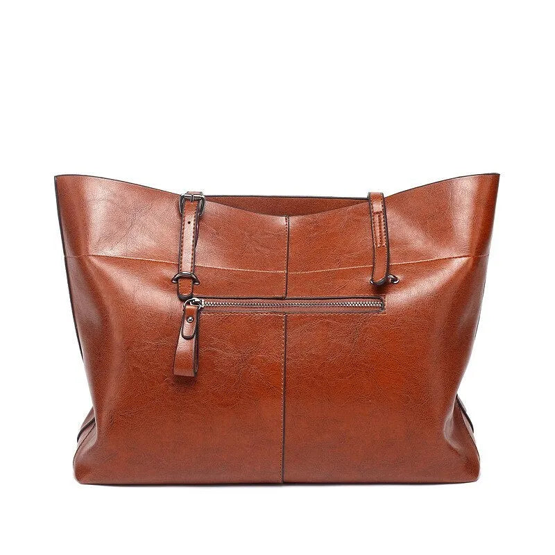 Brown leather cross-body handbag with a horizontal design showing two main compartments and a long strap.